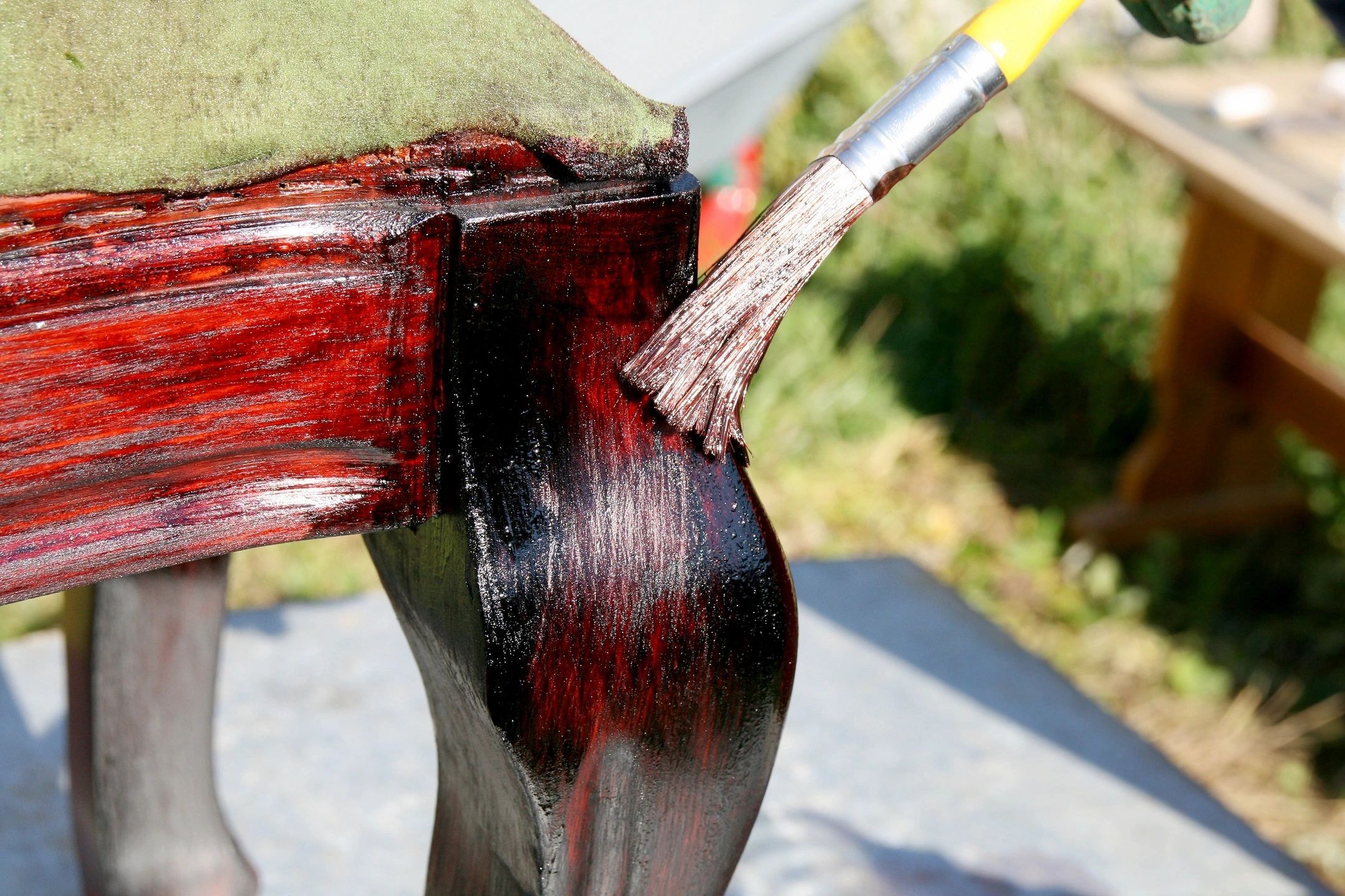 Paintbrush applying paint to wood during restoration